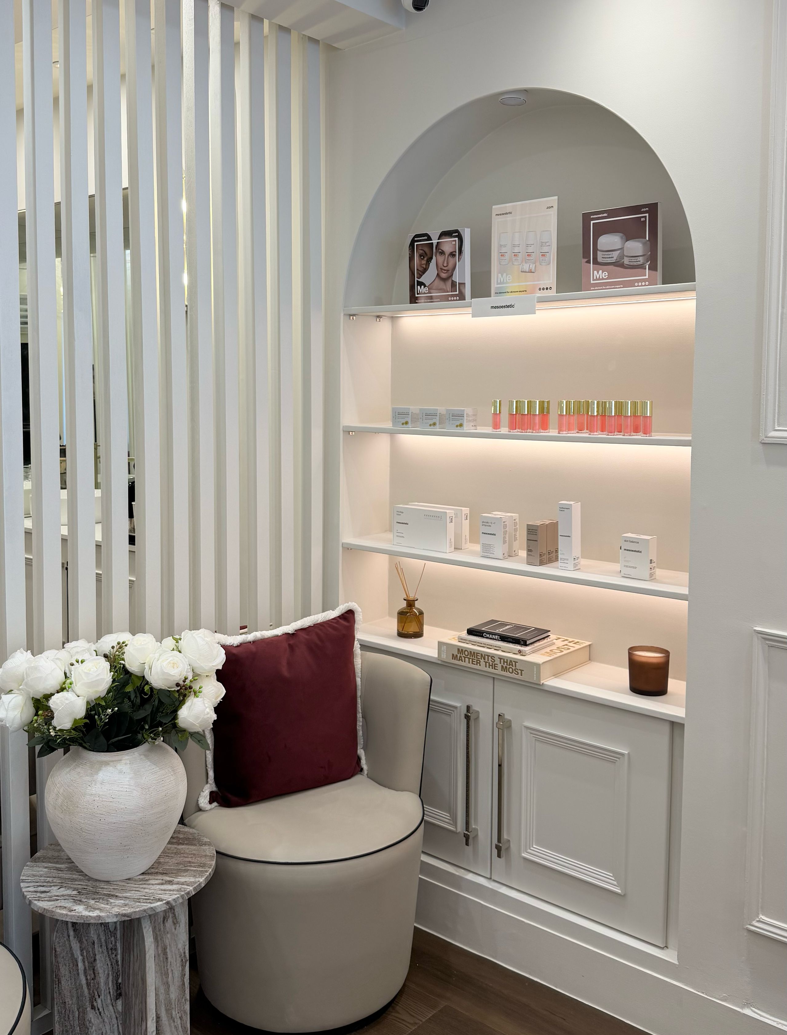 The lit arched niche of skincare beside an armchair at the By Narjis clinic, 17 Thayer Street