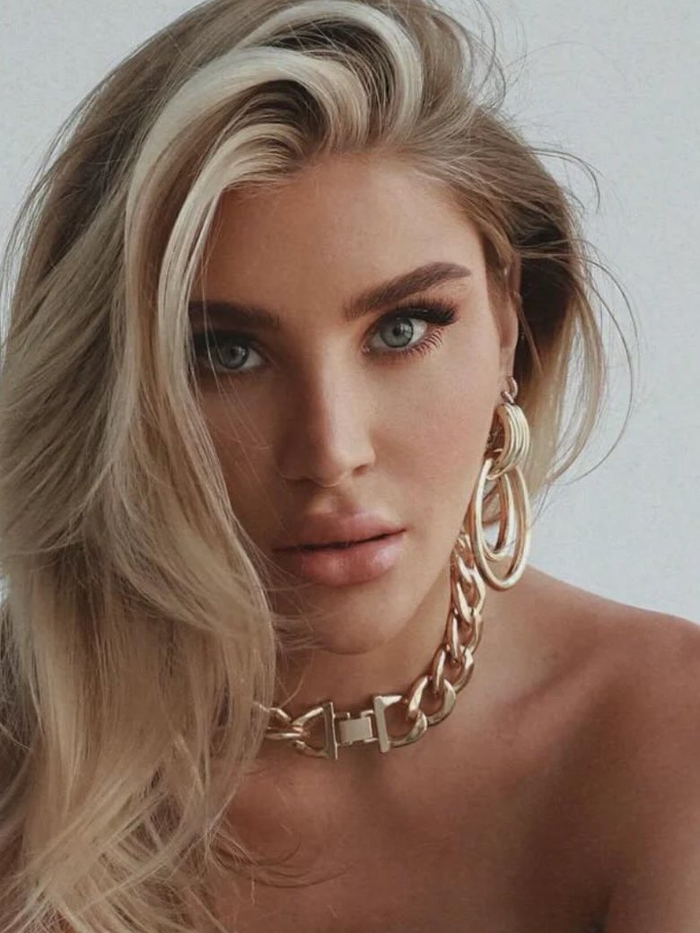 Chloe Othen in a studio portrait, her blonde hair swept to one side, a gold chain at her neck